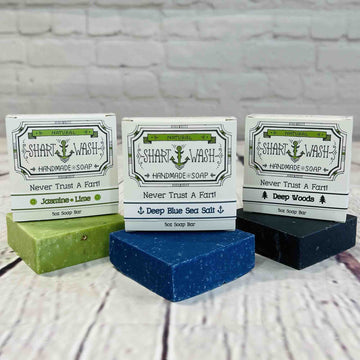 picture of 3 bars of soap with their boxes sitting on top of them. Left to Right - Jasmine lime (green), deep blue sea salt (blue) and deep woods scrub (black)
