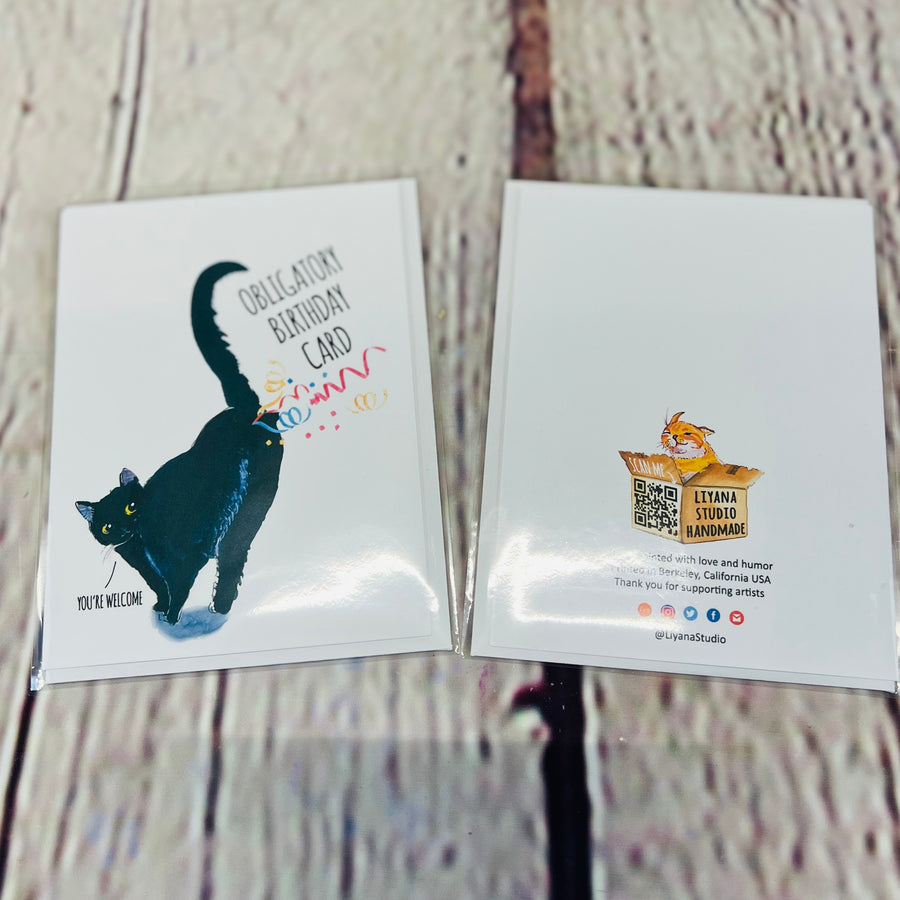 Picture of the front and back of a white birthday card. Front: White birthday card with a picture of a black cat farting confetti. Top text: Obligatory Birthday Card. Bottom Text: Cat saying, 